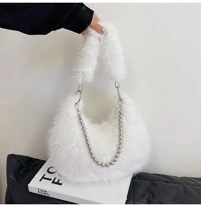 Detail of white fluffy faux fur moon bag with elegant silver beaded chain and soft plush handle