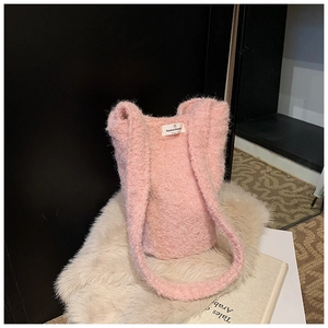 Texture détaillée d'un sac cabas en peluche rose avec étiquette tissée blanche