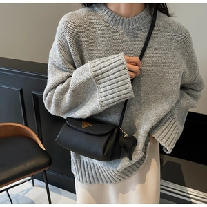 Close-up of black crossbody bag with lychee texture and golden triangle buckle