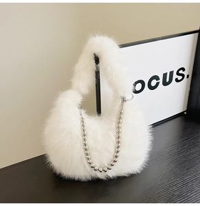 Detail of white faux fur handbag featuring elegant silver beaded chain and plush handle