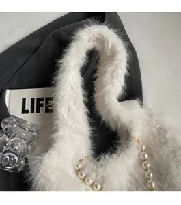 Close-up of white faux fur tote bag featuring a durable pearl beaded shoulder strap