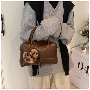 Détail du sac Boston marron foncé avec un charmant cœur en peluche à motif léopard