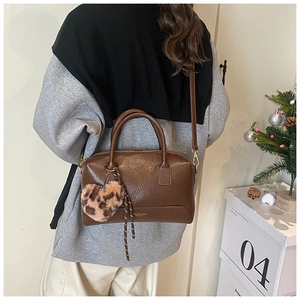 Sac oreiller en cuir marron avec breloque cœur léopard et bandoulière sur un mannequin