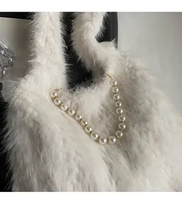 Close-up of fluffy faux fur shoulder bag with elegant pearl and gold bead strap