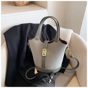 Detail of grey bucket bag with textured matte leather and elegant golden metal buckle