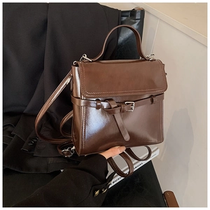 Detailansicht des braunen Vintage-Rucksacks aus Kunstleder mit Zierschnalle und glänzendem Finish