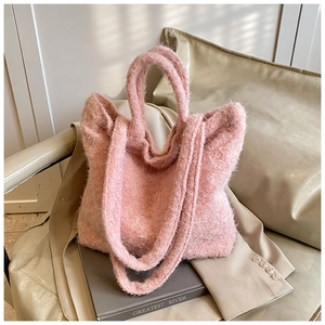 Gros plan sur un sac cabas en tricot rose pelucheux montrant sa texture douce et veloutée