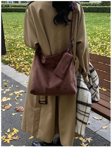Detail of dark brown matte leather tote bag with a matching small hanging pouch