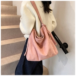 Detail of pink faux suede tote bag featuring a matte texture and golden zipper pendant