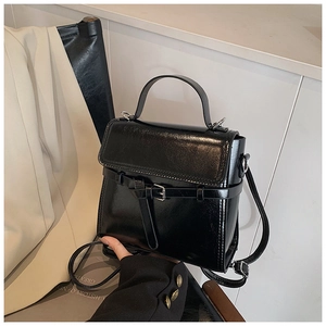 Detail der schwarzen Handtasche aus Öl-Wachsleder mit Glanz-Finish und Schnallenklappe