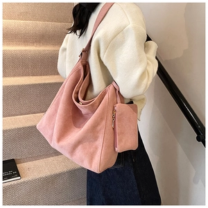Pink suede hobo tote bag detail with adjustable shoulder strap and matching pouch charm