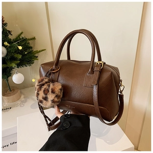 Détail du sac polochon marron vintage avec un charmant pendentif motif léopard