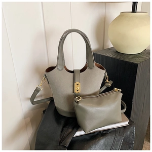 Detail view of grey suede bucket bag with gold clasp and matching inner pouch set
