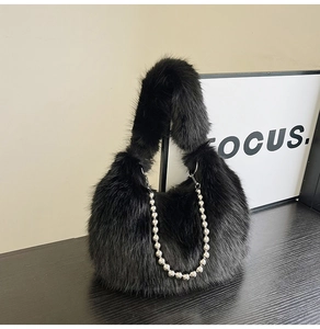 Detail of black faux fur handbag with silver beaded chain handle and plush texture