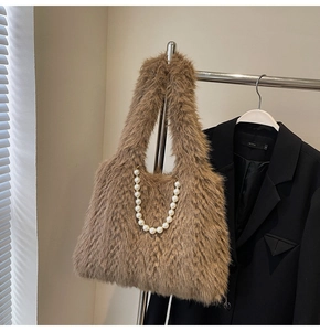 Detail of soft brown faux fur tote bag with decorative white pearl chain strap accents
