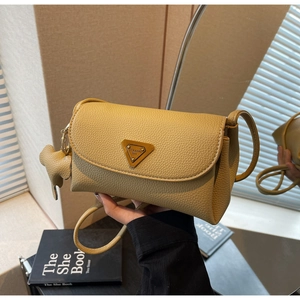 Detail of beige litchi grain leather shoulder bag with logo plaque and elephant charm