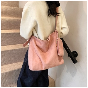 Close-up of pink suede tote bag with matching small coin purse on a stylish shoulder strap