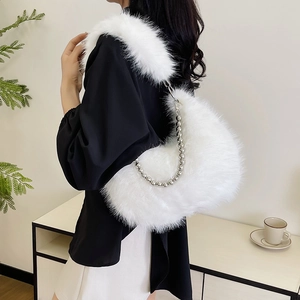 Detail of white fluffy faux fur shoulder bag with silver beaded metal chain strap
