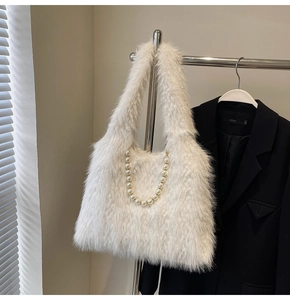 Detailed close-up of white plush faux fur tote bag with pearl chain detail on a hanger