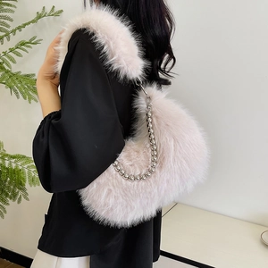 Detail of plush faux fox fur handbag in pale pink with silver beaded metal chain