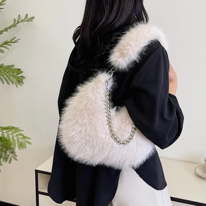 Detail of plush beige shoulder bag with silver beaded chain and fuzzy faux fur strap
