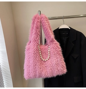 Detail of pink faux fur shoulder bag featuring large decorative pearls and soft plush texture