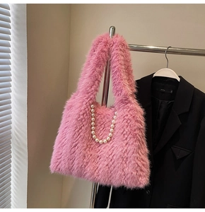 Detailed close-up of pink faux fur handbag featuring luxury pearl chain and soft plush texture