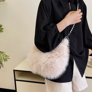 Detail of pink plush shoulder bag featuring chic silver bead chain and soft faux fur texture
