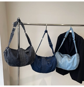 Detailed comparison of three washed denim crescent bags in grey, navy, and light blue shades