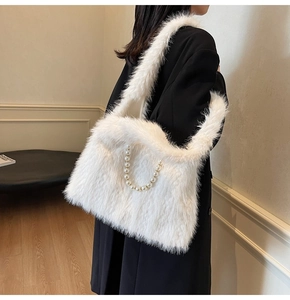 Detail of white faux fur tote bag with pearl chain accessory on a black wool coat