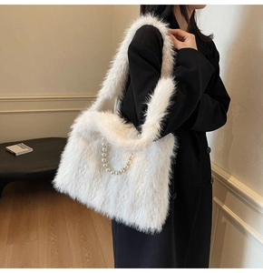 Close-up of white faux fur shoulder bag with decorative pearl chain strap detail