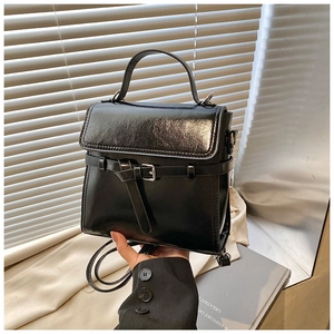 Details einer vintage schwarzen Lackleder-Handtasche mit Silberschnalle und Umhängegurt