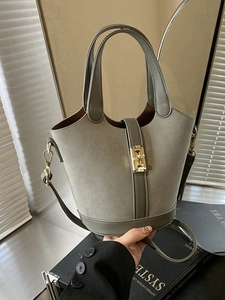 Vintage sage green bucket bag with golden buckle and leather straps in a stylish setting