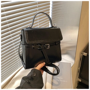 Detailansicht einer schwarzen Vintage-Handtasche mit Lederstruktur und Riemenschnalle