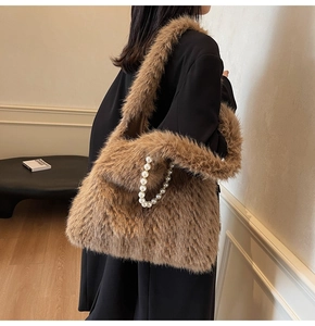 Detail of plush brown shoulder bag with elegant large pearl chain and soft faux fur texture