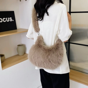 Brown faux fur shoulder bag worn by model, showing soft plush texture and crescent shape