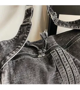 Detail shot of smooth double metal zippers with denim pullers on washed denim bag