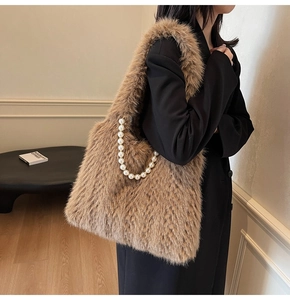 Detailed macro view of brown faux fur tote bag with decorative white pearl chain strap