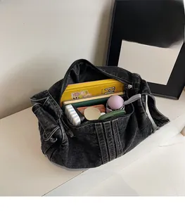 Interior view showing large storage capacity of black denim tote bag with daily items