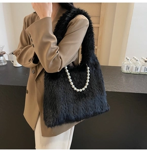 Close-up of black faux fur shoulder bag featuring decorative pearl handle chain detail