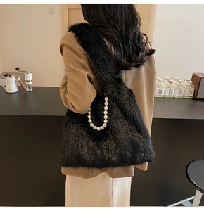 Detail of plush black faux fur tote bag featuring elegant large pearl chain handle
