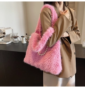 Detail of pink faux fur tote bag featuring white pearl chain strap in a cafe setting