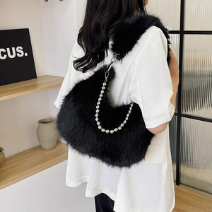 Detail view of black faux fur hobo bag with silver beaded metal chain strap on model