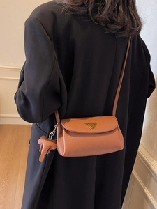 Brown lychee leather crossbody bag with triangle metal logo and elephant charm