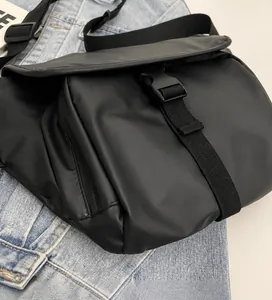 Detailopname van een zwarte vintage messenger bag met gesp en gladde, zachte stof.