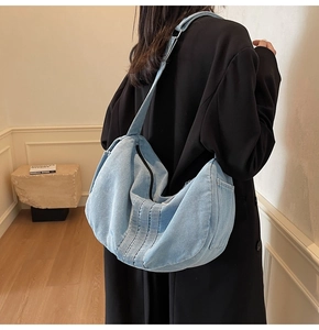Back view of a model wearing a light blue washed denim tote bag for daily commuting