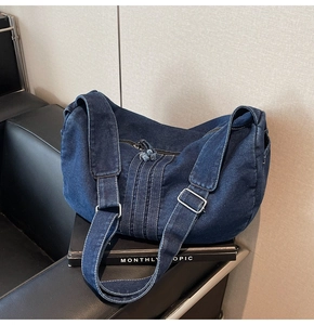 Detail of adjustable strap and silver buckle on a vintage denim hobo shoulder bag