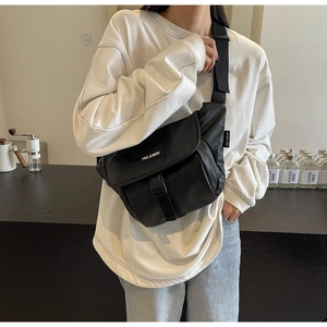 Detailed view of black nylon messenger bag with buckle closure and wide shoulder strap