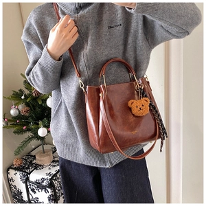 Brown vintage faux leather tote bag with teddy bear pendant and polka dot scarf detail