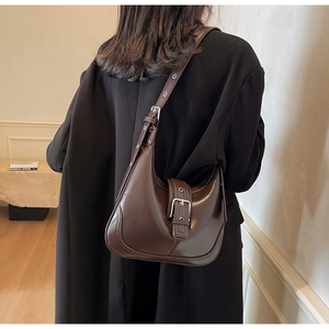 Dettaglio di una borsa hobo marrone scuro con fibbia argento e tracolla regolabile